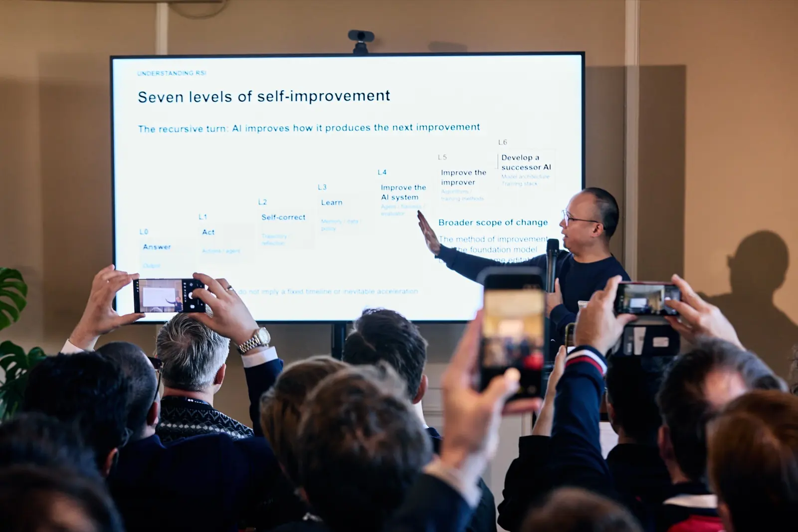 Audience photographing the seven levels of self-improvement slide